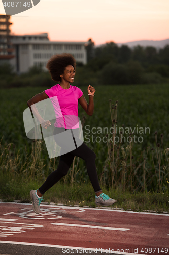 Image of a young African American woman jogging outdoors