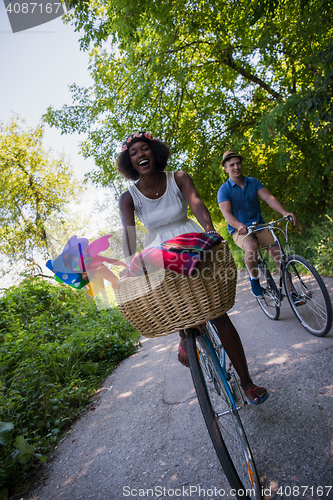 Image of Young multiethnic couple having a bike ride in nature
