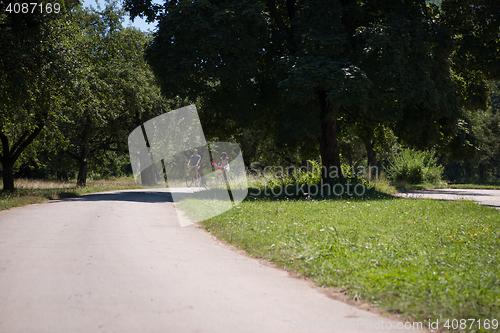 Image of Young multiethnic couple having a bike ride in nature