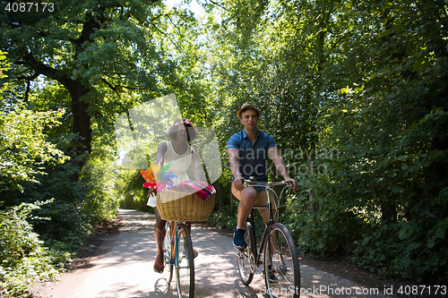 Image of Young multiethnic couple having a bike ride in nature