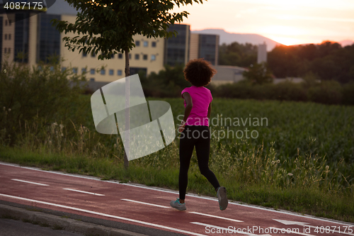 Image of a young African American woman jogging outdoors