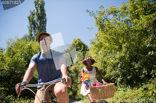 Image of Young multiethnic couple having a bike ride in nature