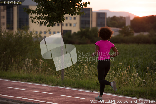 Image of a young African American woman jogging outdoors