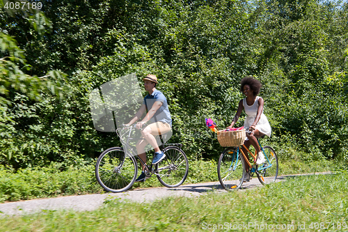 Image of Young multiethnic couple having a bike ride in nature