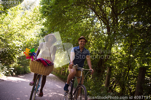 Image of Young multiethnic couple having a bike ride in nature