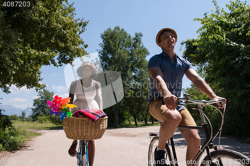 Image of Young multiethnic couple having a bike ride in nature