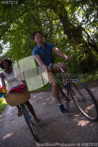 Image of Young multiethnic couple having a bike ride in nature