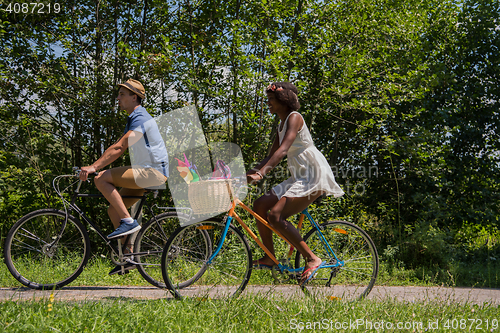 Image of Young multiethnic couple having a bike ride in nature