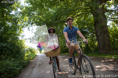 Image of Young multiethnic couple having a bike ride in nature