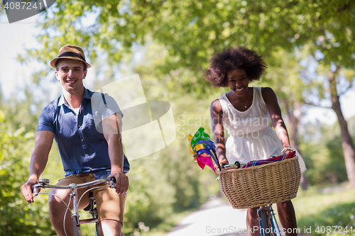 Image of Young multiethnic couple having a bike ride in nature