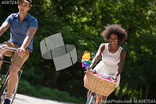 Image of Young multiethnic couple having a bike ride in nature