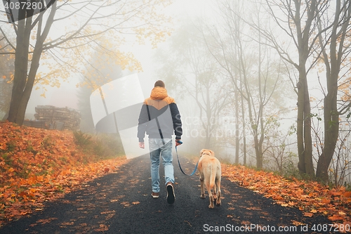 Image of Man with dog in autumn nature