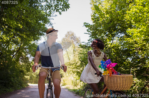 Image of Young multiethnic couple having a bike ride in nature