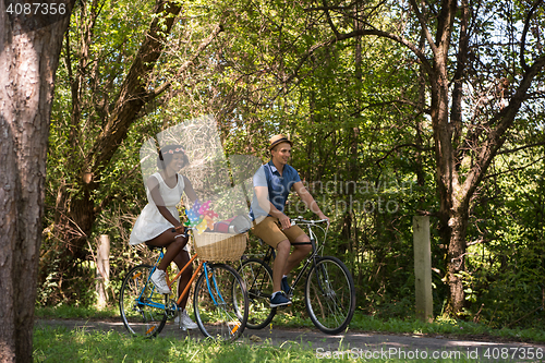 Image of Young multiethnic couple having a bike ride in nature