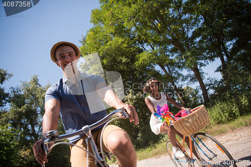 Image of Young multiethnic couple having a bike ride in nature