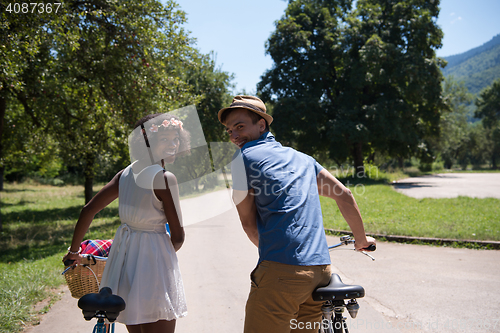 Image of Young multiethnic couple having a bike ride in nature