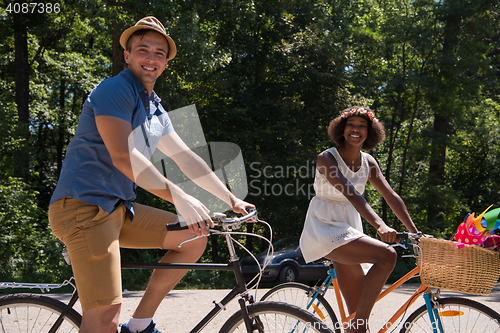 Image of Young multiethnic couple having a bike ride in nature