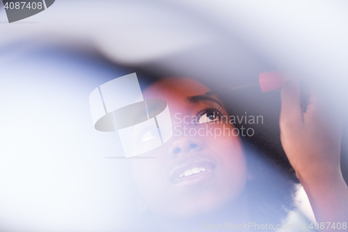 Image of a young African-American woman makeup in the car