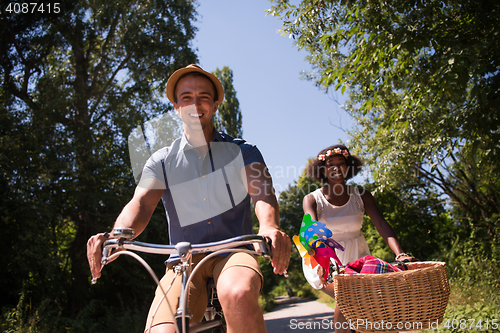 Image of Young multiethnic couple having a bike ride in nature