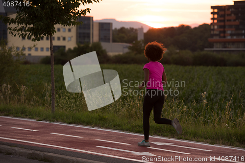 Image of a young African American woman jogging outdoors