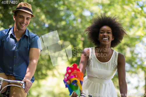 Image of Young multiethnic couple having a bike ride in nature