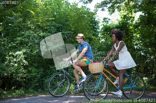 Image of Young multiethnic couple having a bike ride in nature