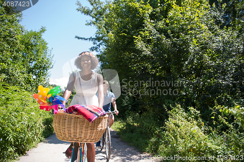 Image of Young multiethnic couple having a bike ride in nature