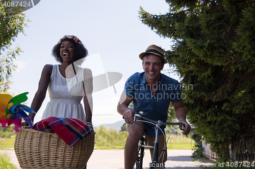 Image of Young multiethnic couple having a bike ride in nature