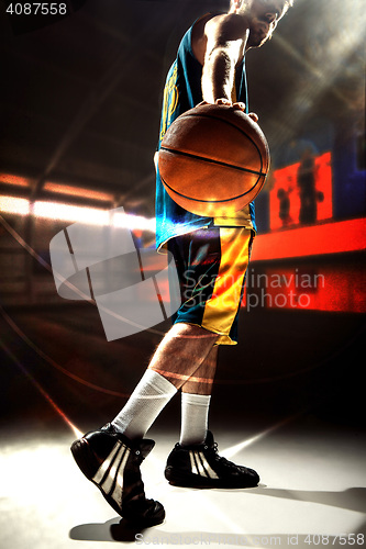 Image of Silhouette view of a basketball player holding basket ball on black background