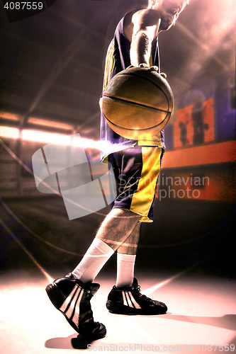 Image of Silhouette view of a basketball player holding basket ball