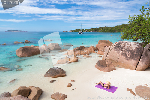 Image of Woman sunbathing at Anse Lazio picture perfect beach on Praslin Island, Seychelles.