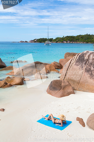 Image of Woman sunbathing at Anse Lazio picture perfect beach on Praslin Island, Seychelles.