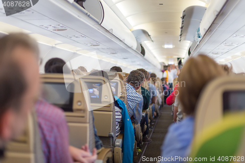 Image of Interior of airplane with passengers on seats waiting to taik off.