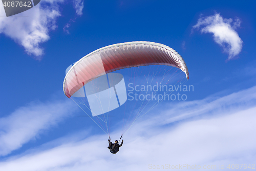 Image of Paragliding on background of blue sky and white clouds