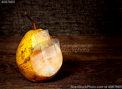 Image of One bitten pear on a wooden table