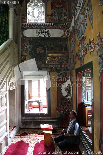 Image of Muslim man reading the Koran in the Aladza painted mosque,Tetovo, Macedonia