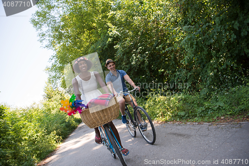 Image of Young multiethnic couple having a bike ride in nature