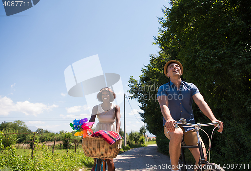 Image of Young multiethnic couple having a bike ride in nature