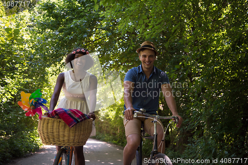 Image of Young multiethnic couple having a bike ride in nature