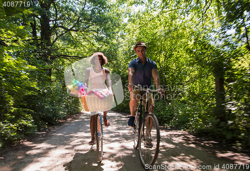 Image of Young multiethnic couple having a bike ride in nature