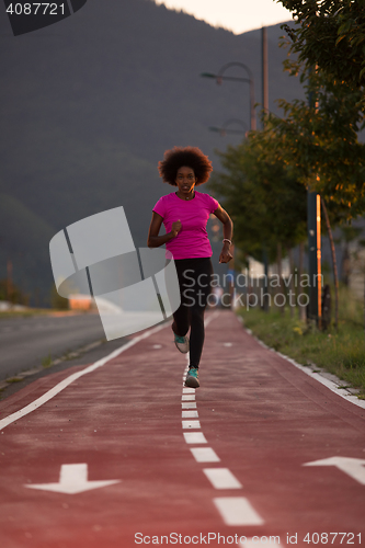 Image of a young African American woman jogging outdoors