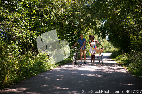 Image of Young multiethnic couple having a bike ride in nature