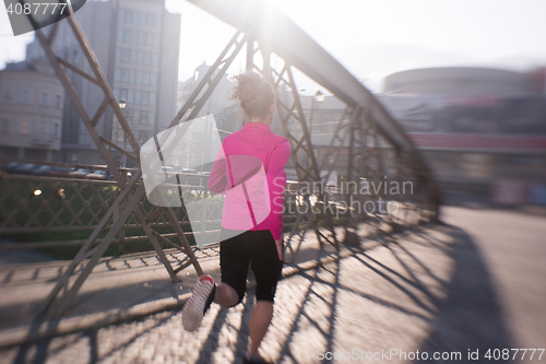 Image of sporty woman jogging on morning