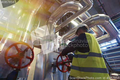 Image of factory worker turning valve