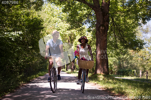 Image of Young multiethnic couple having a bike ride in nature