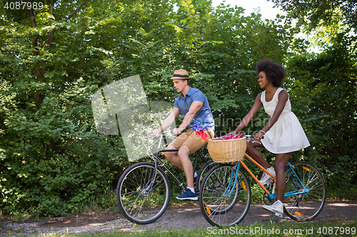 Image of Young multiethnic couple having a bike ride in nature