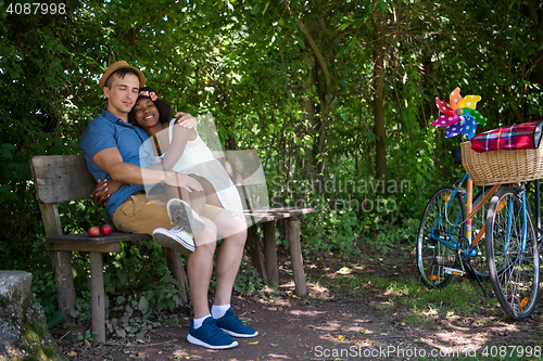 Image of Young multiethnic couple having a bike ride in nature