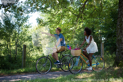 Image of Young multiethnic couple having a bike ride in nature