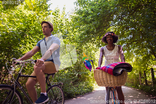 Image of Young multiethnic couple having a bike ride in nature