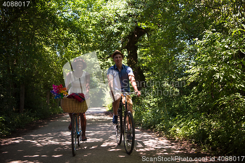 Image of Young multiethnic couple having a bike ride in nature